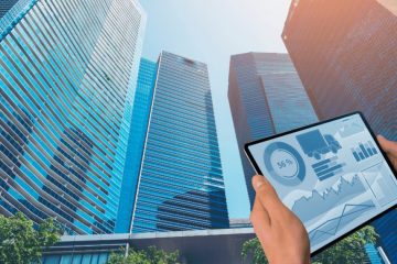 Edifícios empresariais e tablet com gráficos de investimento