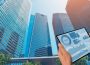 Edifícios empresariais e tablet com gráficos de investimento